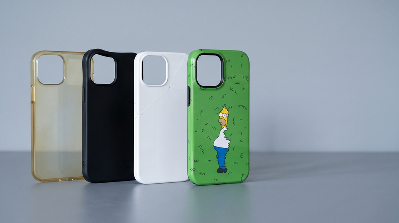 Four phone cases in a row: yellowed clear, slack silicone, cracked rigid shell, and an intact Homer Fade tough case